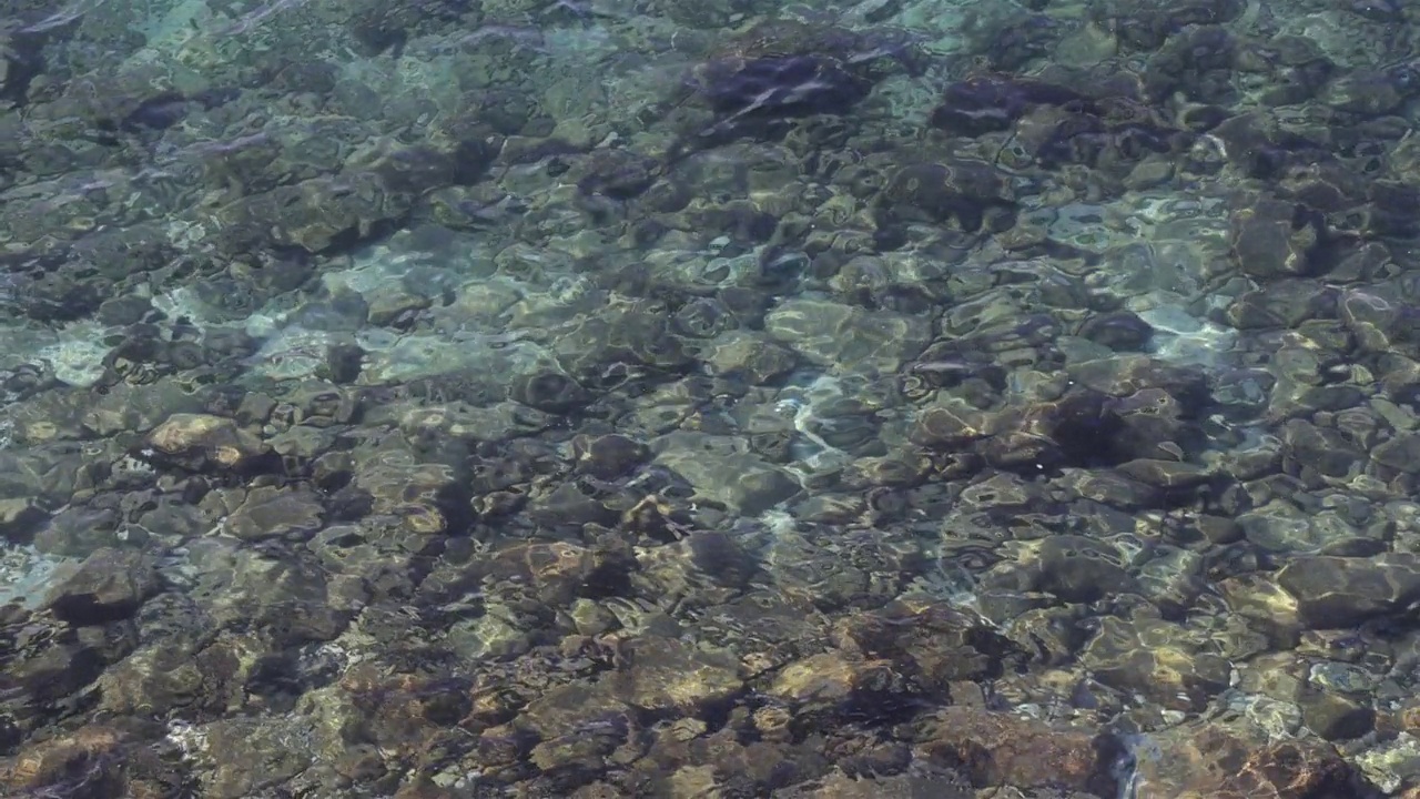 鸟瞰图，蓝色的海浪在底部的石头上视频素材