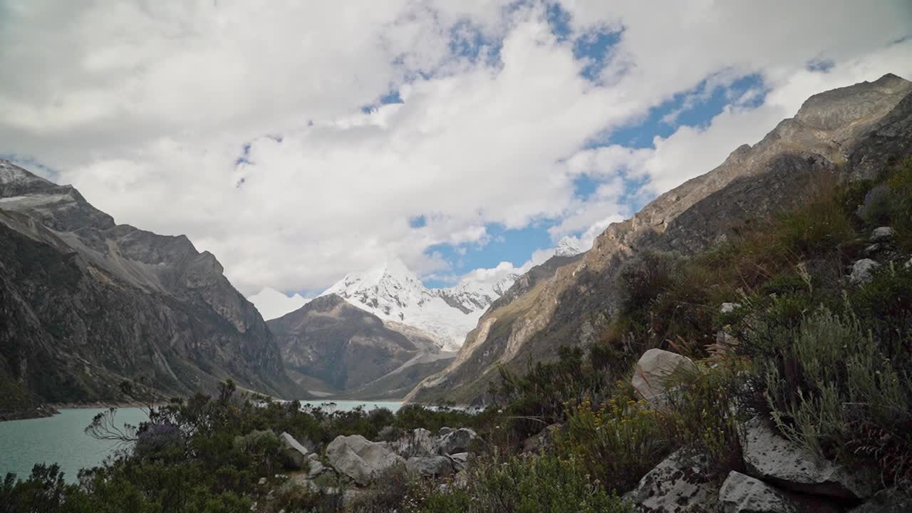 美丽的绿松石湖水在拉古纳帕隆泻湖在安第斯山脉的高山山脉在秘鲁华斯卡兰，雪山覆盖的山峰在一个明媚的阳光灿烂的一天。视频素材