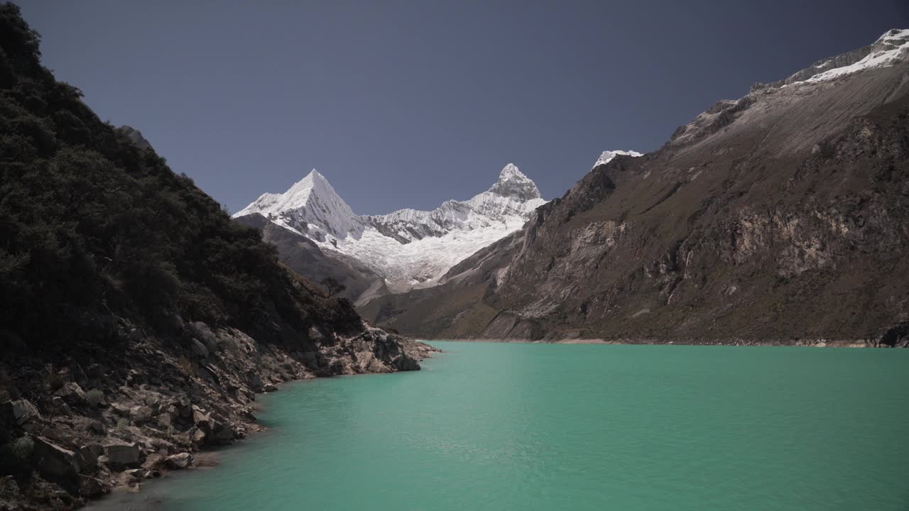 美丽的绿松石湖水在拉古纳帕隆泻湖在安第斯山脉的高山山脉在秘鲁华斯卡兰，雪山覆盖的山峰在一个明媚的阳光灿烂的一天。视频素材