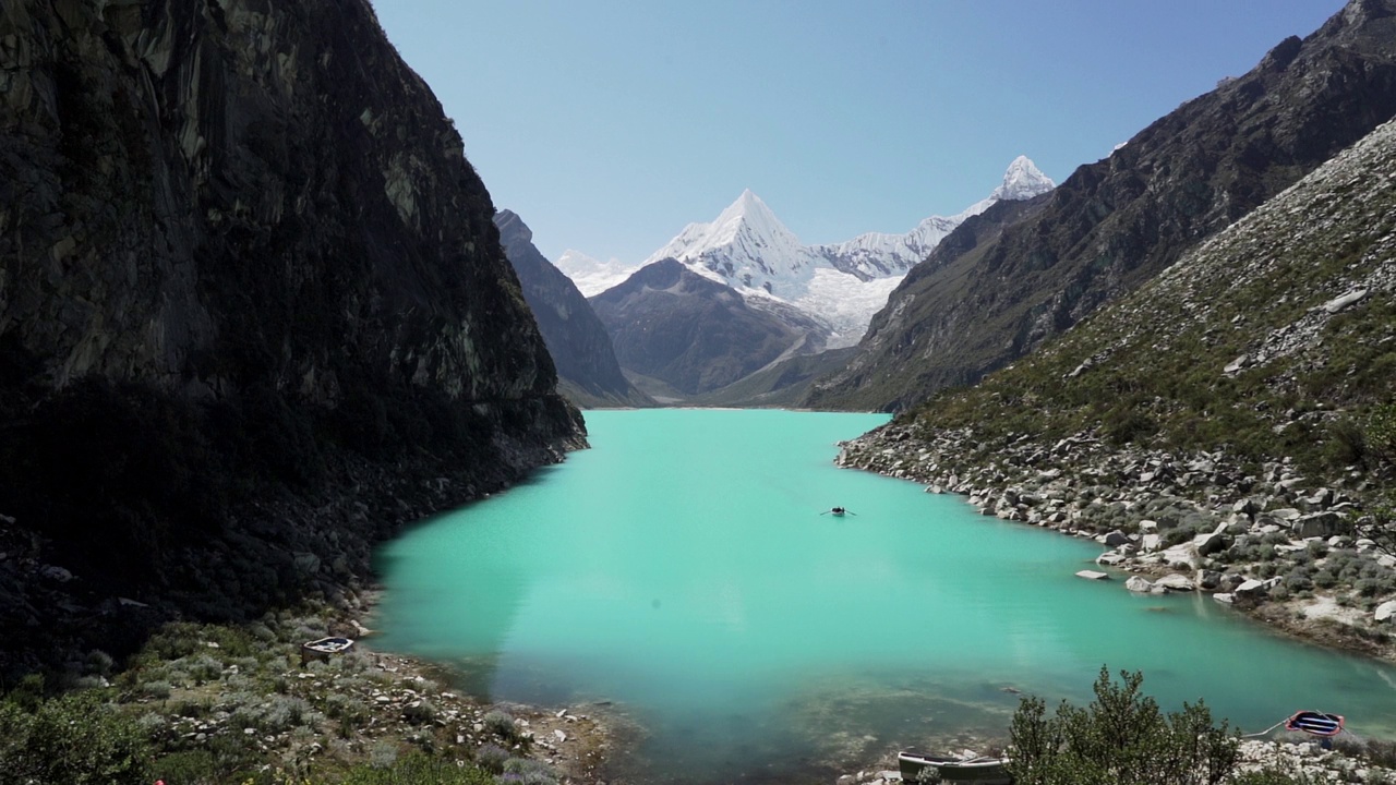 美丽的绿松石湖水在拉古纳帕隆泻湖在安第斯山脉的高山山脉在秘鲁华斯卡兰，雪山覆盖的山峰在一个明媚的阳光灿烂的一天。视频素材