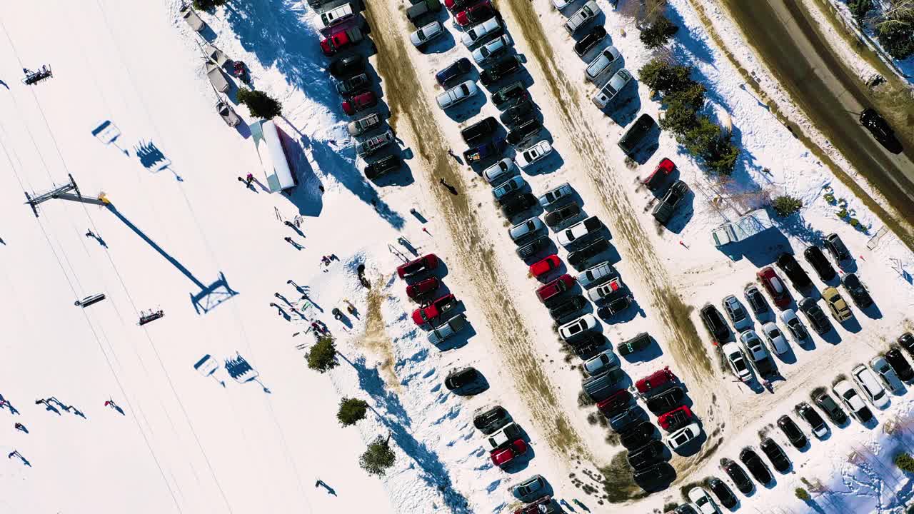 空中无人机的繁忙的滑雪场和完整的停车场，人们乘坐缆车在拥挤的步道。冬季运动和探险视频素材