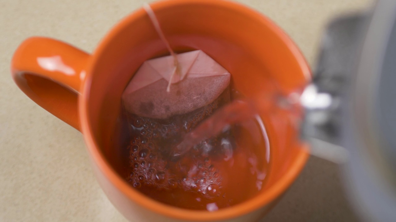 用茶包饮料将热水壶水壶的水倒入茶杯马克杯的特写慢动作镜头厨房早餐香气清晨4K视频素材