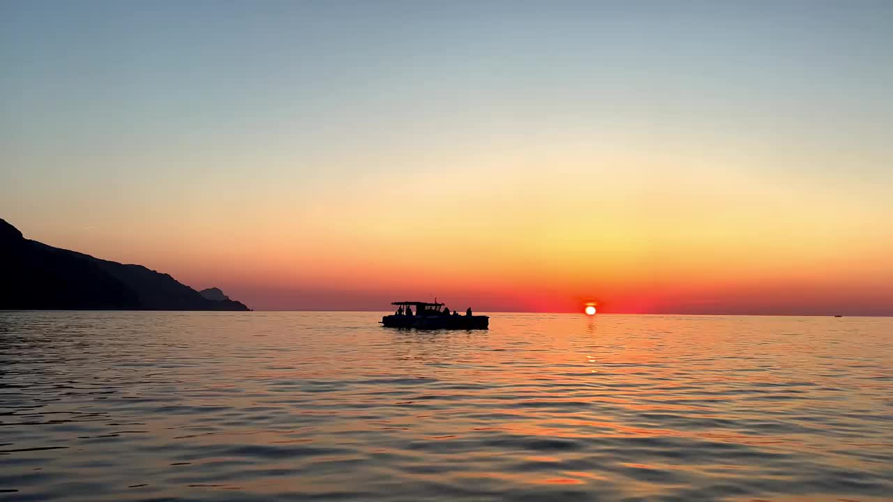 日落时航行船的剪影，太阳在地平线上视频素材