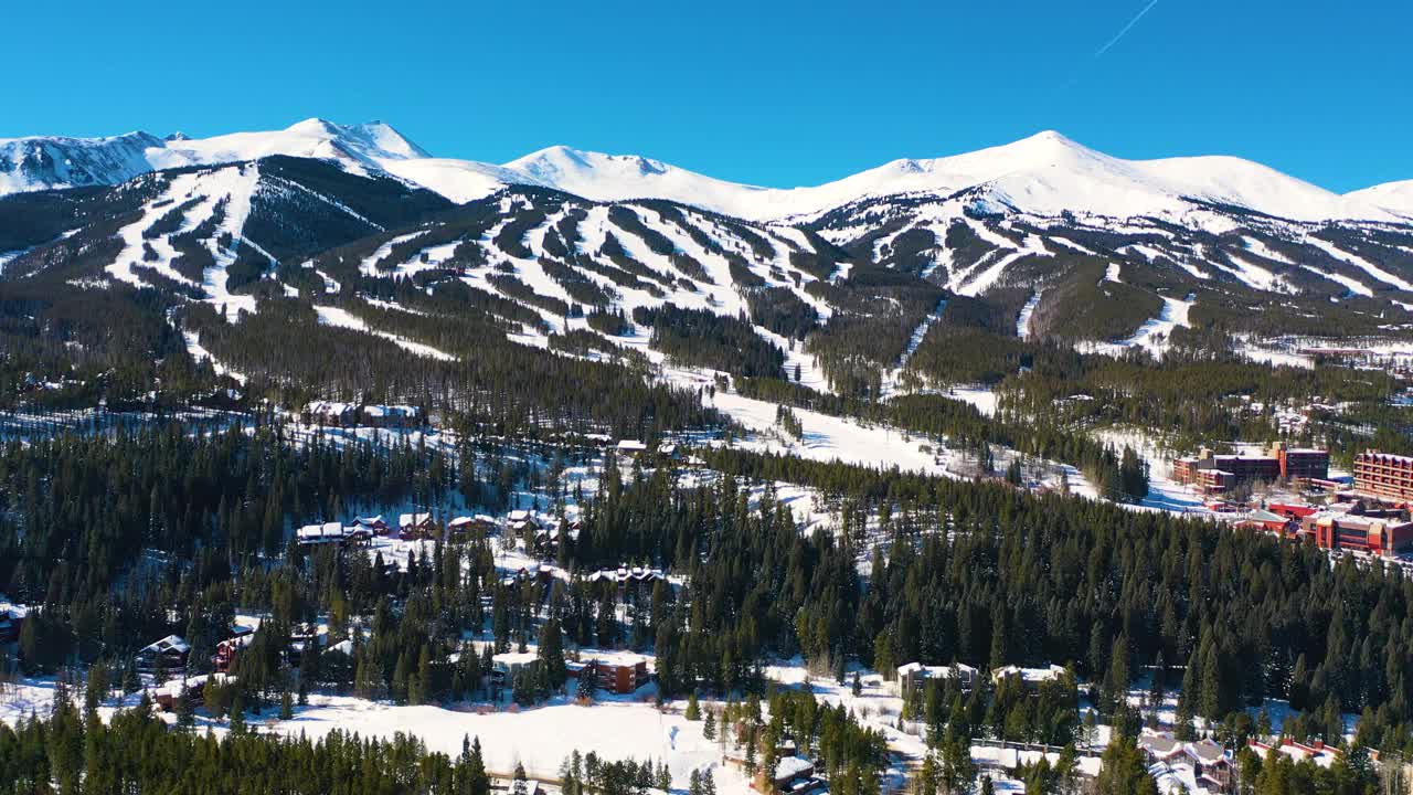 雪道上美丽的山顶覆盖着白色的粉末雪。空中无人机观察寒冷的冬季天气假期视频素材