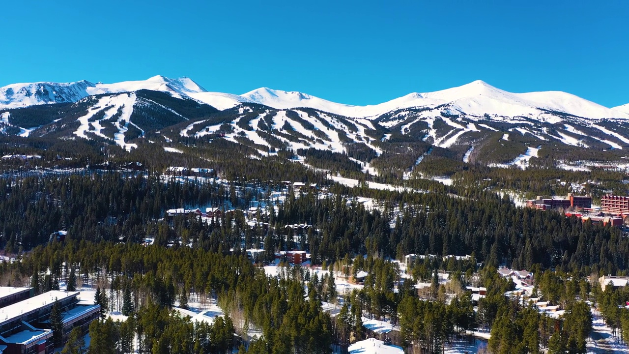 冰雪覆盖的冬季山峰与滑雪道的空中无人机视图准备在厚厚的松树林中进行户外运动和冒险视频素材