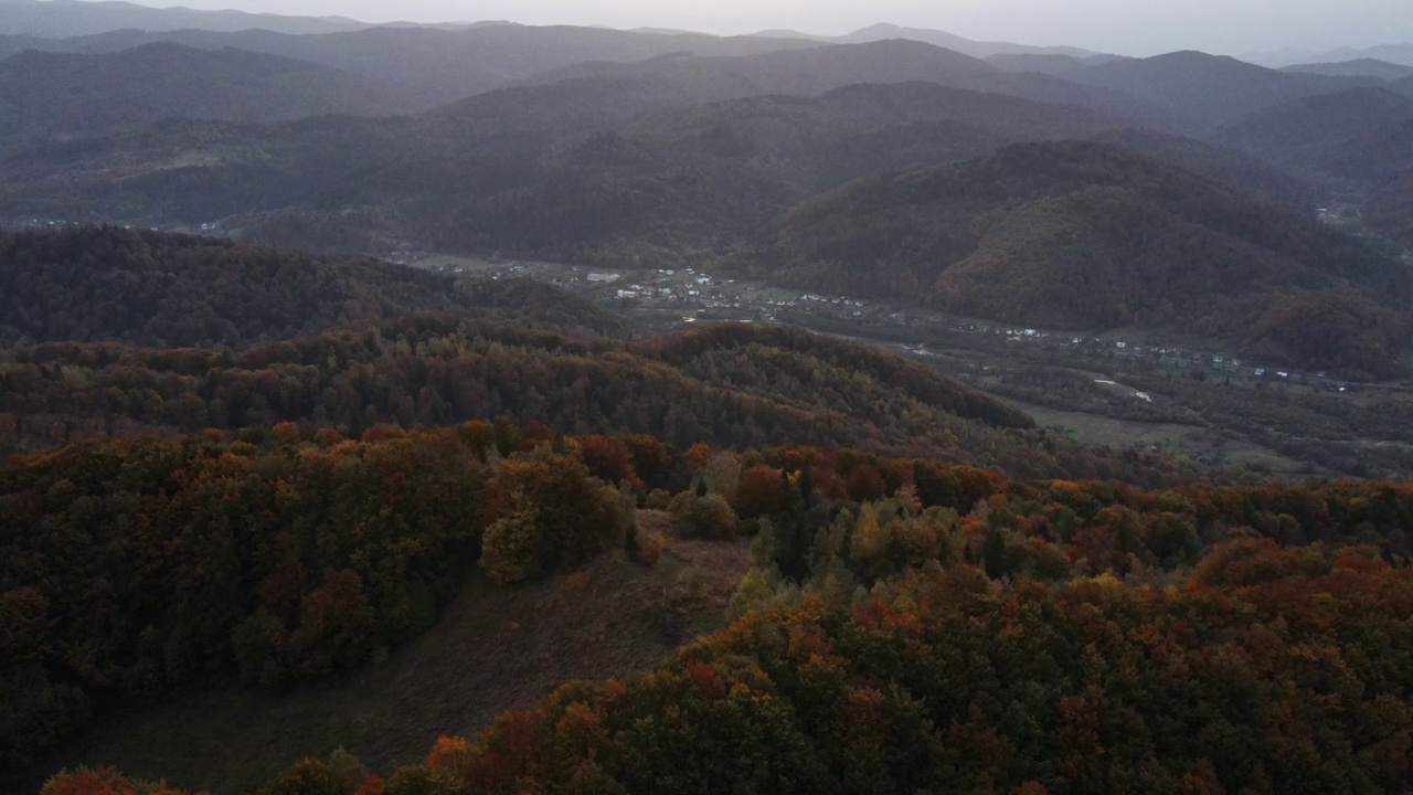 鸟瞰乡村，令人惊叹的山脉和美丽多彩的秋天森林，乡村地区的背景秋天景观。无人机在晚上飞越树梢的画面，自然概念视频素材