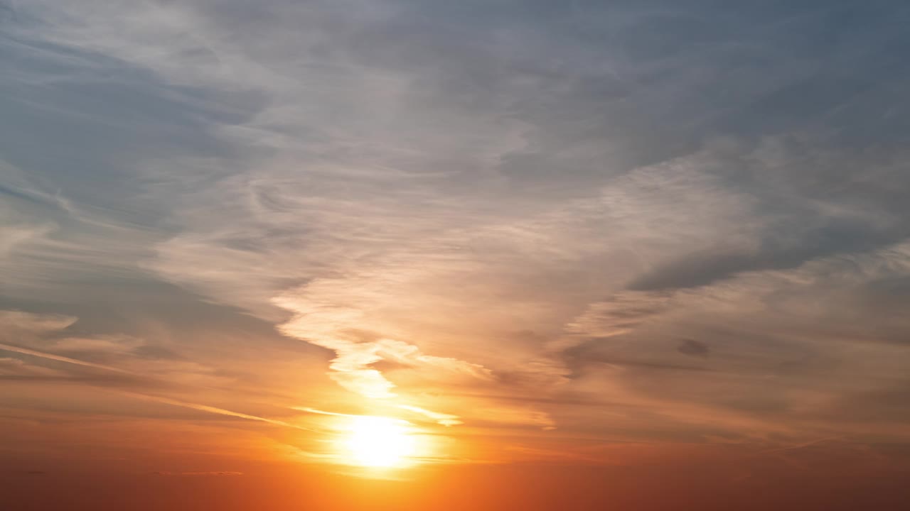 时间流逝。夕阳把天空中的云染成不同的颜色，从橙色到紫红色视频下载