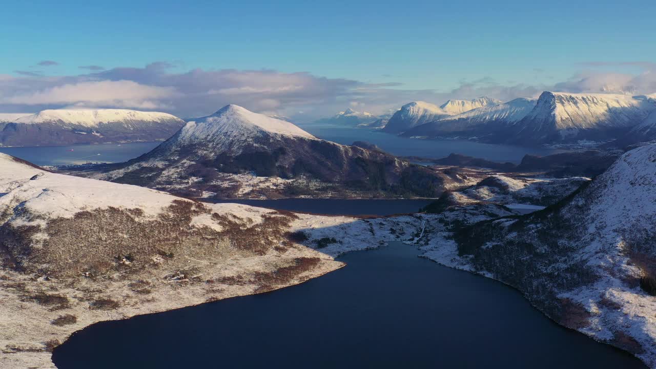 戏剧性的空中冬季山景观与冰冻的湖泊和峡湾在风景秀丽的日落在挪威冬季视频素材