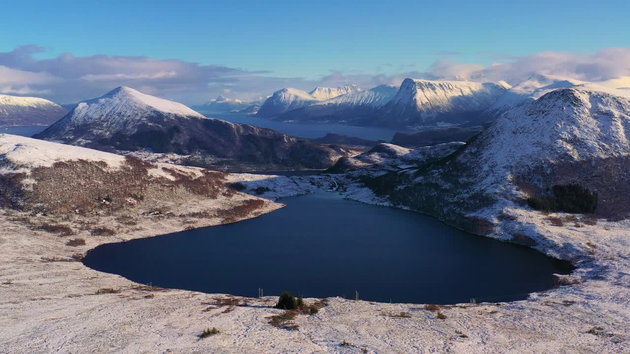 戏剧性的空中冬季山景观与冰冻的湖泊和峡湾在风景秀丽的日落在挪威冬季视频素材