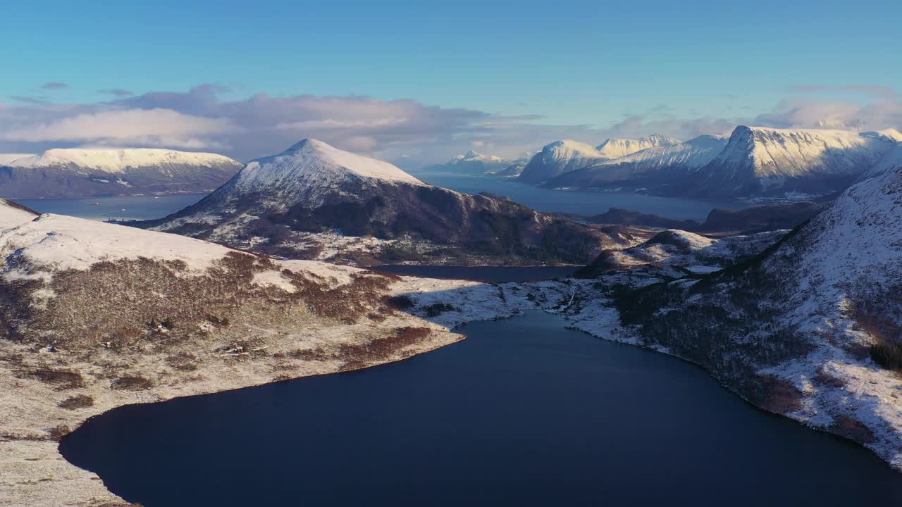 戏剧性的空中冬季山景观与冰冻的湖泊和峡湾在风景秀丽的日落在挪威冬季视频素材