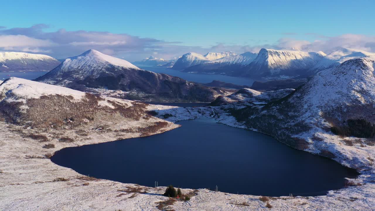 戏剧性的空中冬季山景观与冰冻的湖泊和峡湾在风景秀丽的日落在挪威冬季视频素材