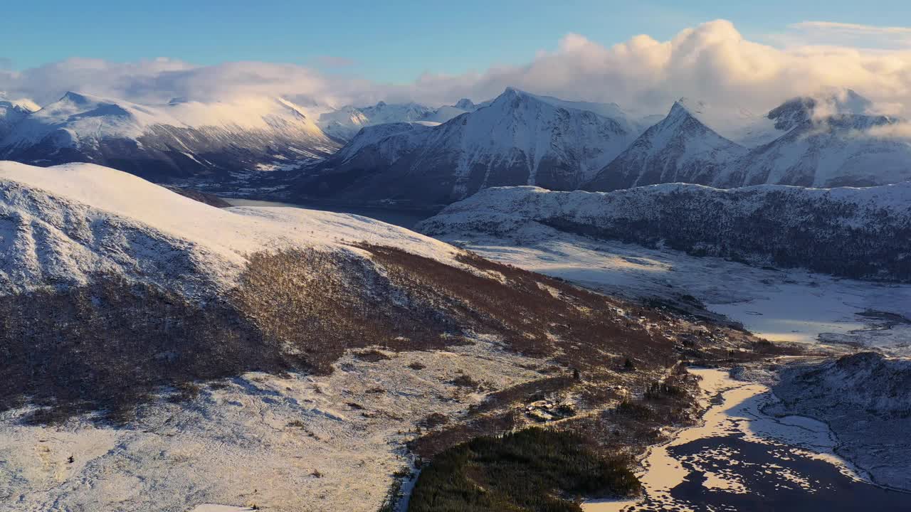 戏剧性的空中冬季山景观与冰冻的湖泊和峡湾在风景秀丽的日落在挪威冬季视频素材