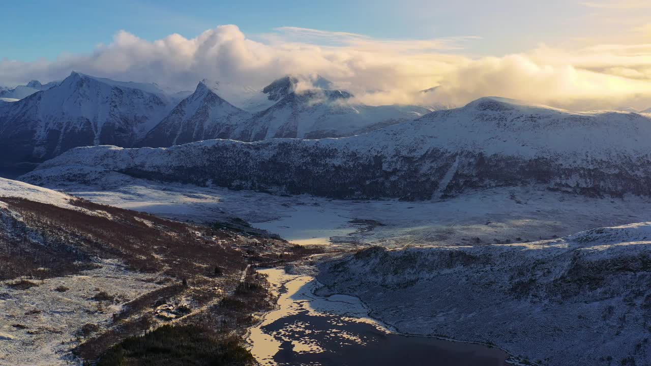 戏剧性的空中冬季山景观与冰冻的湖泊和峡湾在风景秀丽的日落在挪威冬季视频素材