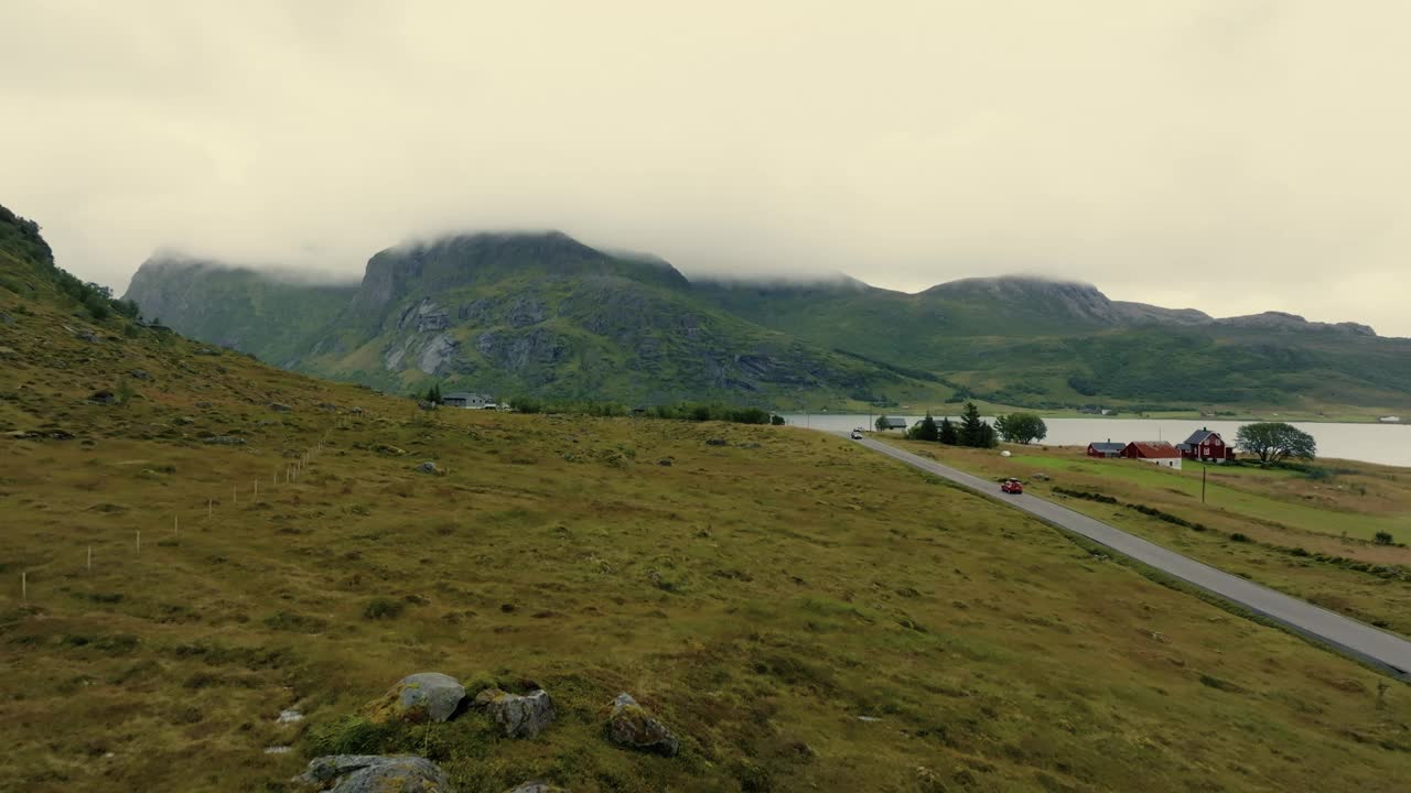 美丽的全景汽车，驾驶的道路与北欧湖和绿色峡湾为背景。视频素材