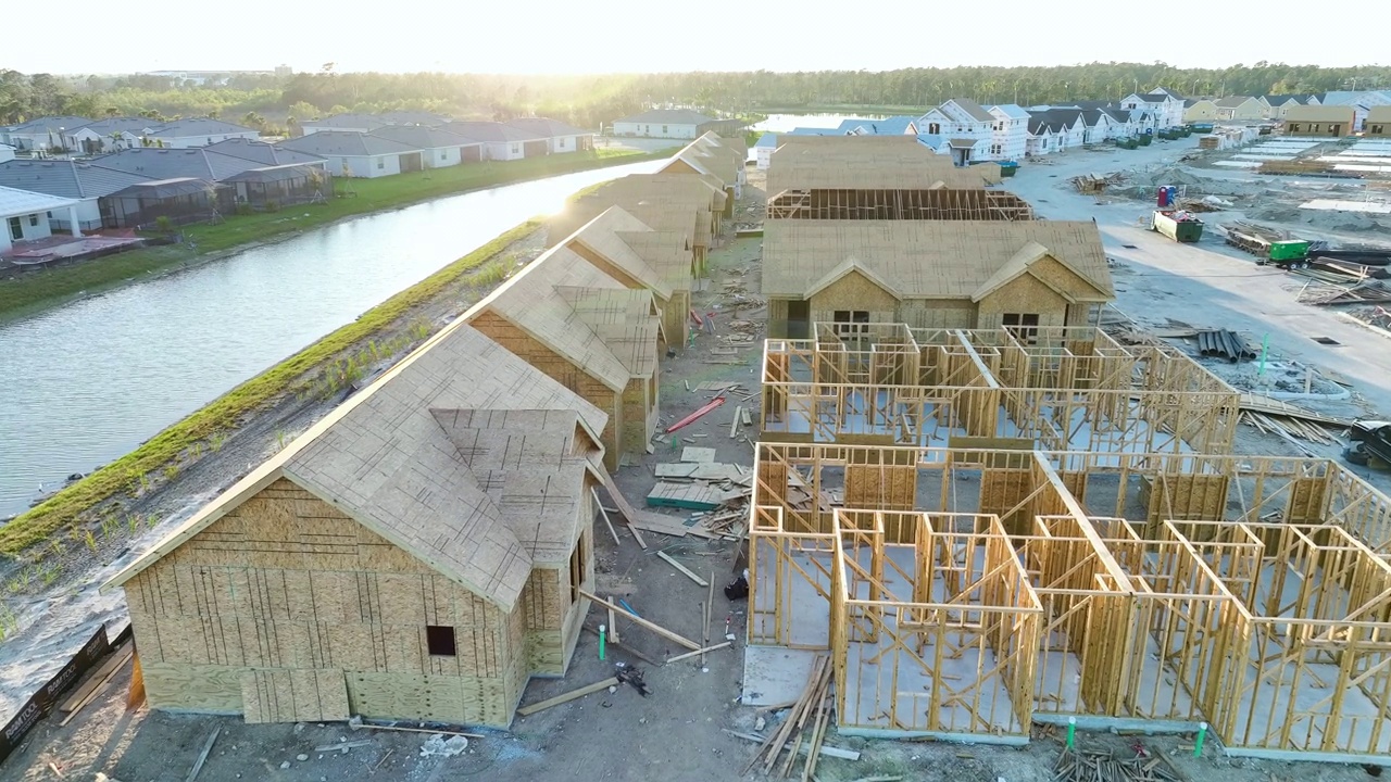 从上面看正在建造的木质屋顶梁的廉价房屋的未完工框架。美国郊区住宅的发展。美国的房地产市场视频素材