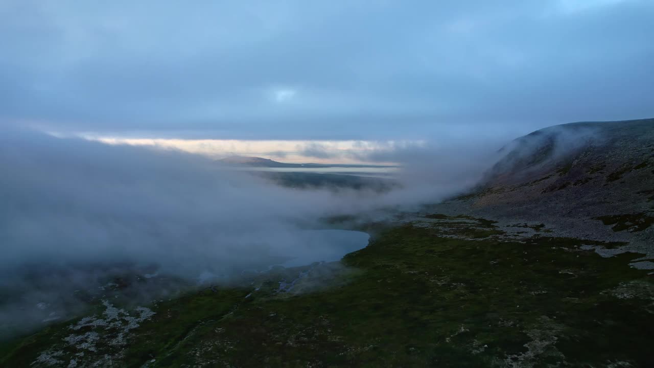 清晨，在云雾缭绕的苔原山谷上空飞行，沿途有一个小小的山间湖泊视频素材