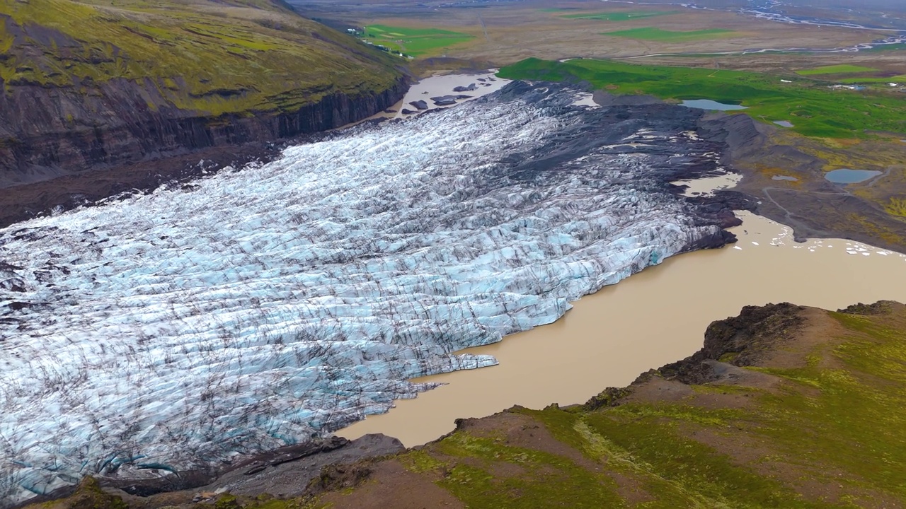 Svínafellsjökull冰川的鸟瞰图揭示了冰冻的冰层与崎岖的地形相遇视频素材