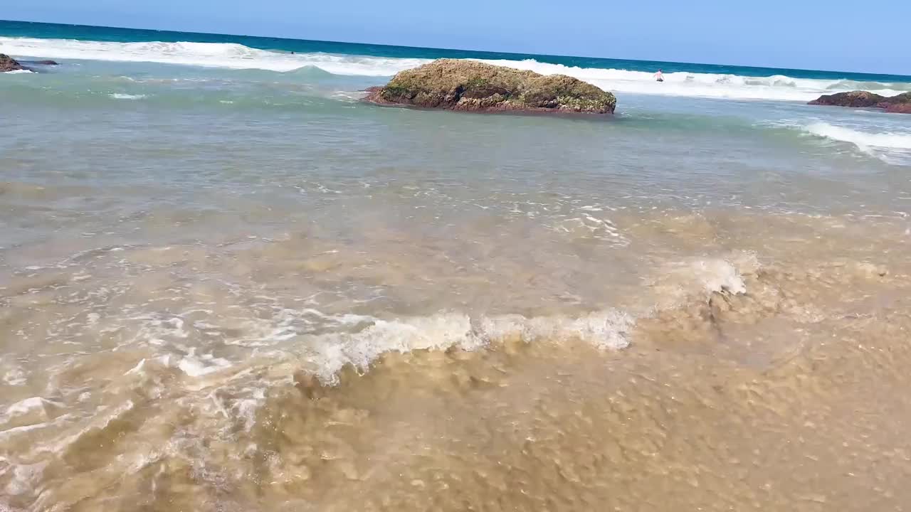 海浪冲刷着清澈的黄色沙滩。空中俯瞰自然海景。天堂岛海岸澳大利亚，海湾，岩石山，蓝天旅游度假视频素材