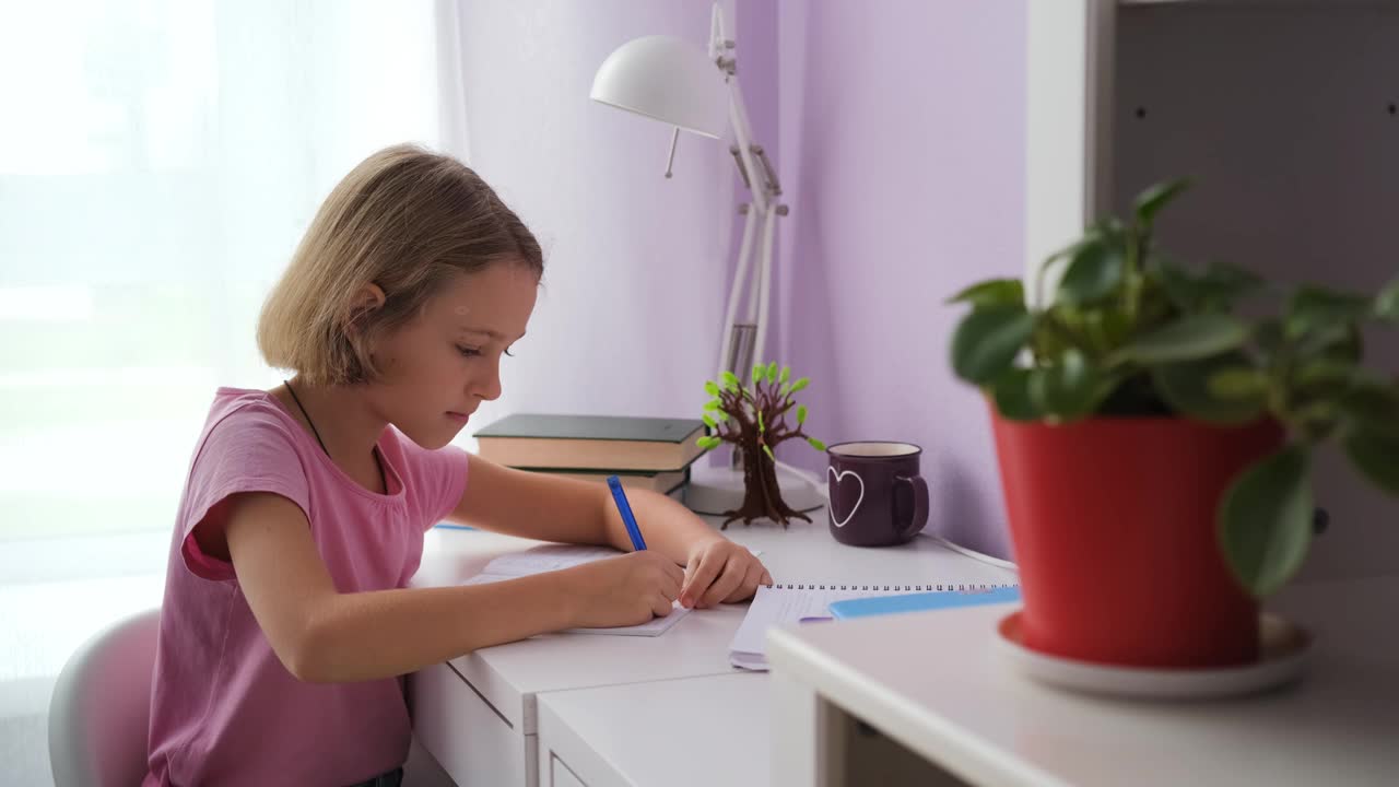 勤奋的小女孩在她的课桌上做作业视频素材