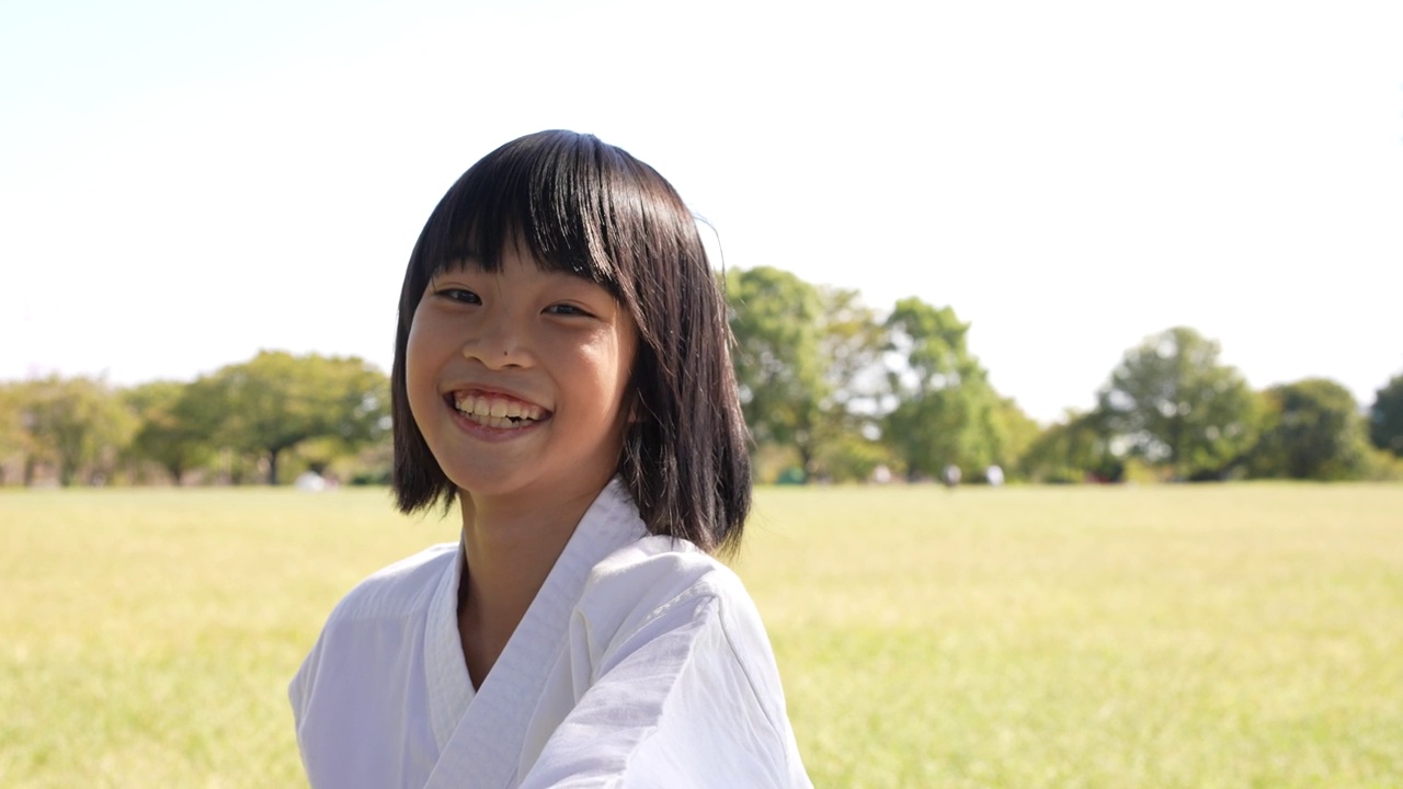 一个小学女生的脸特写，微笑着重复空手道的拳视频下载