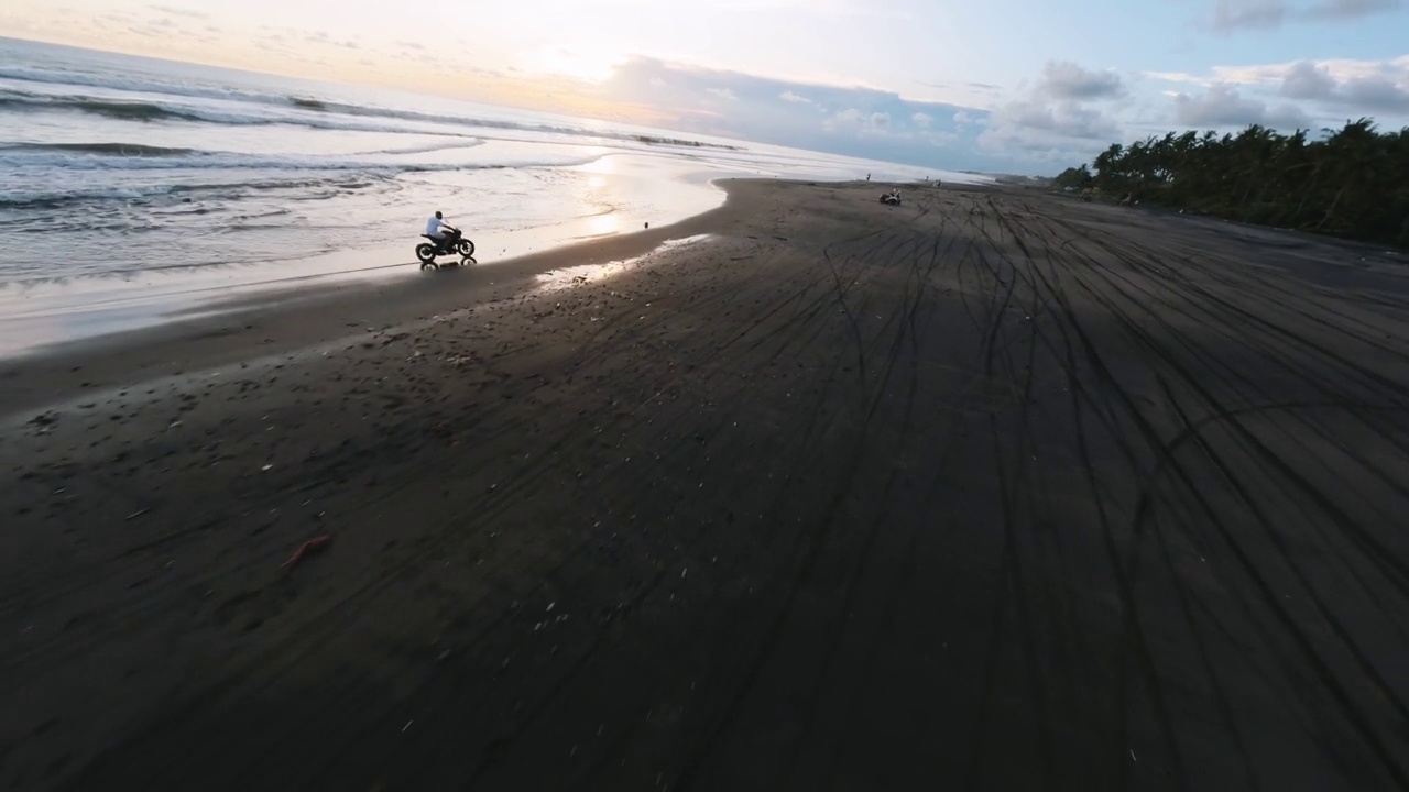 空中跟随骑自行车的人定制自行车热带沙滩傍晚日落视频素材