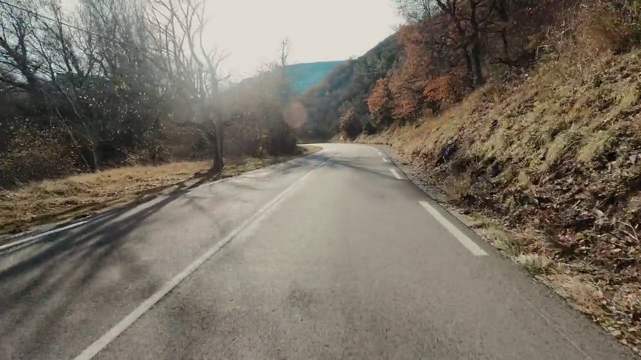 在蓝天和地平线的背景下，在一条长长的柏油直路上开车。旅游和交通的概念。山区国家公园。开车到目的地。节日假期。视频素材