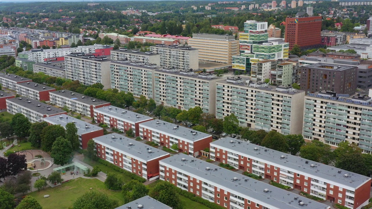 鸟瞰图，市区内有高层住宅楼，周围环绕着低层街区、公园和城市设施。视频下载