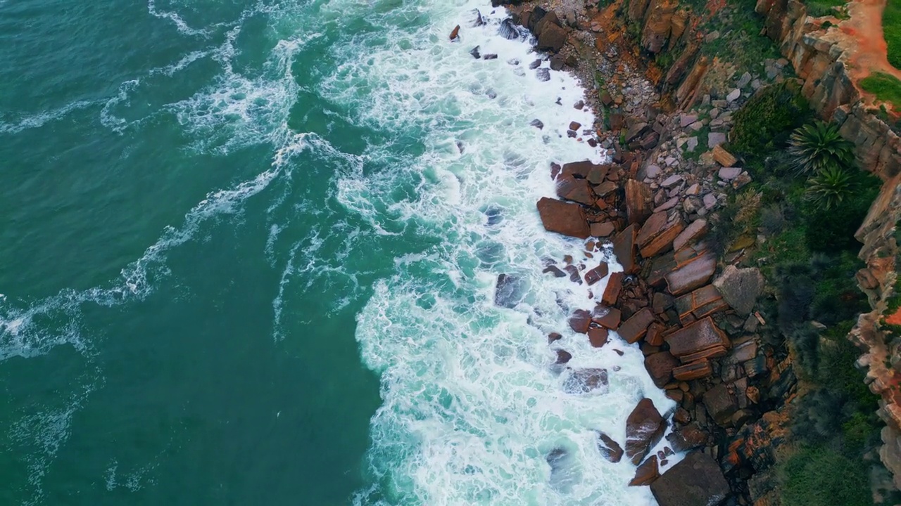 暴风骤雨的大海顶着海岸的石头打起了泡沫。空中坠海海岸视频素材