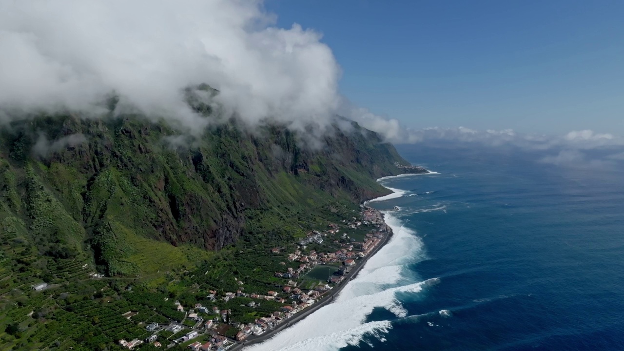 海浪冲击着海岸，而云从Fajã da Ovelha的山上滚下来视频素材