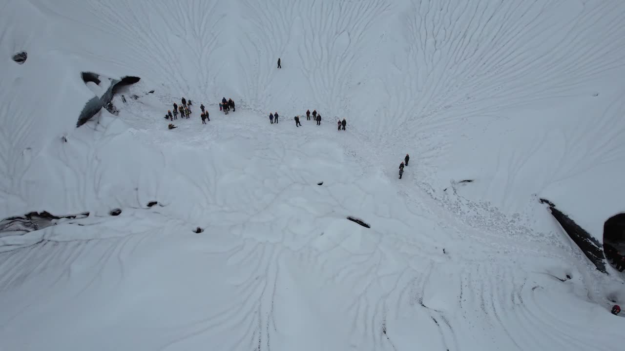 鸟瞰冰岛冰川火山口、雪山和崎岖的冬季景观中的生态游客视频素材