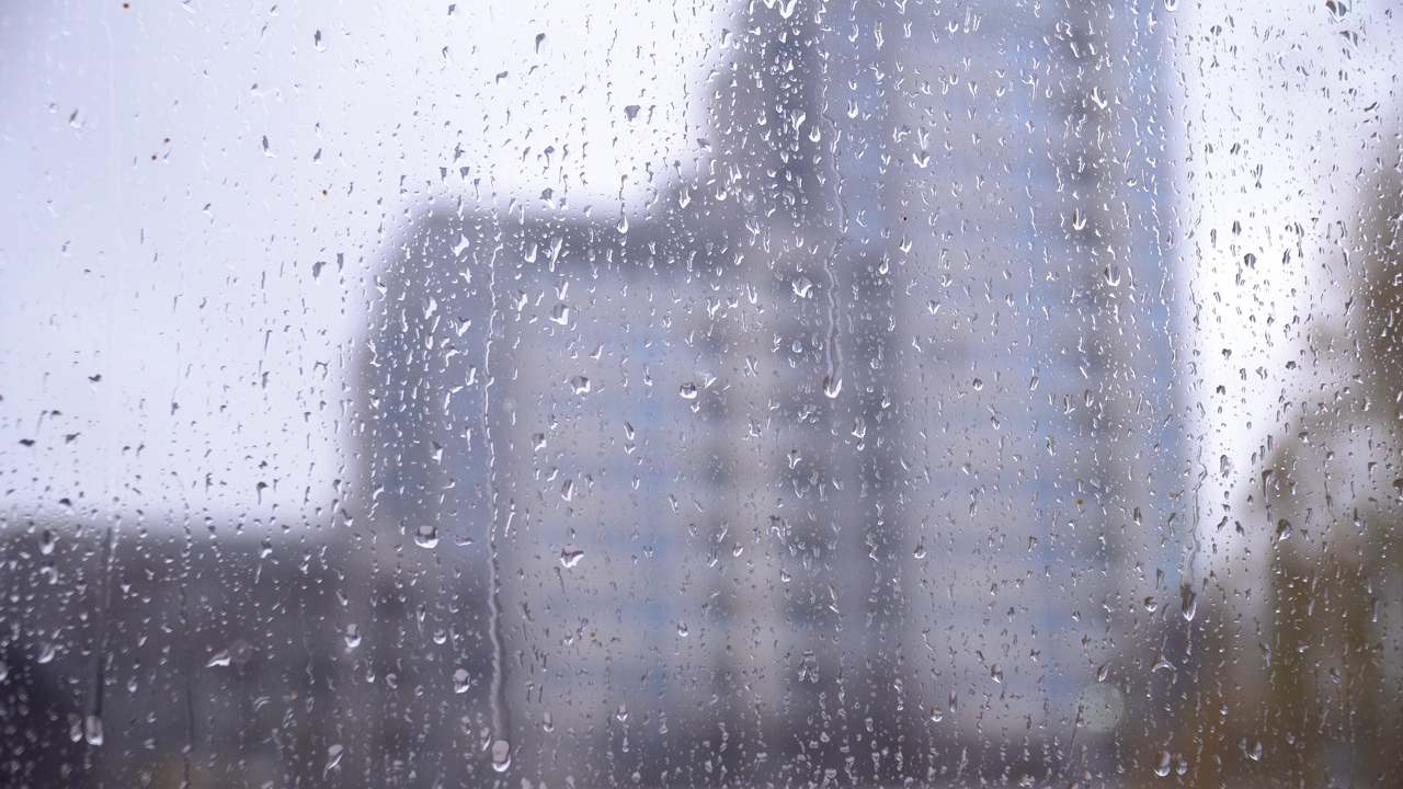 雨滴落在窗玻璃上。窗外背景模糊视频下载