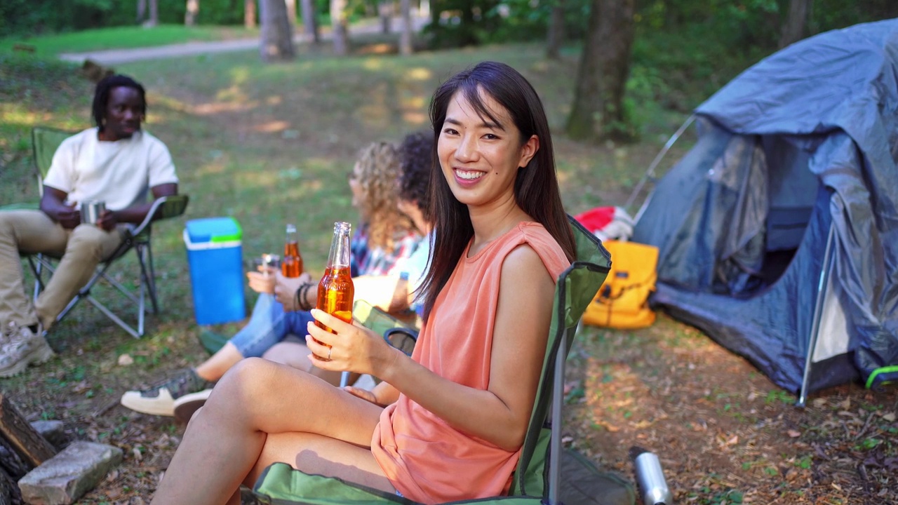 一个女人和朋友在森林里露营时的肖像视频素材