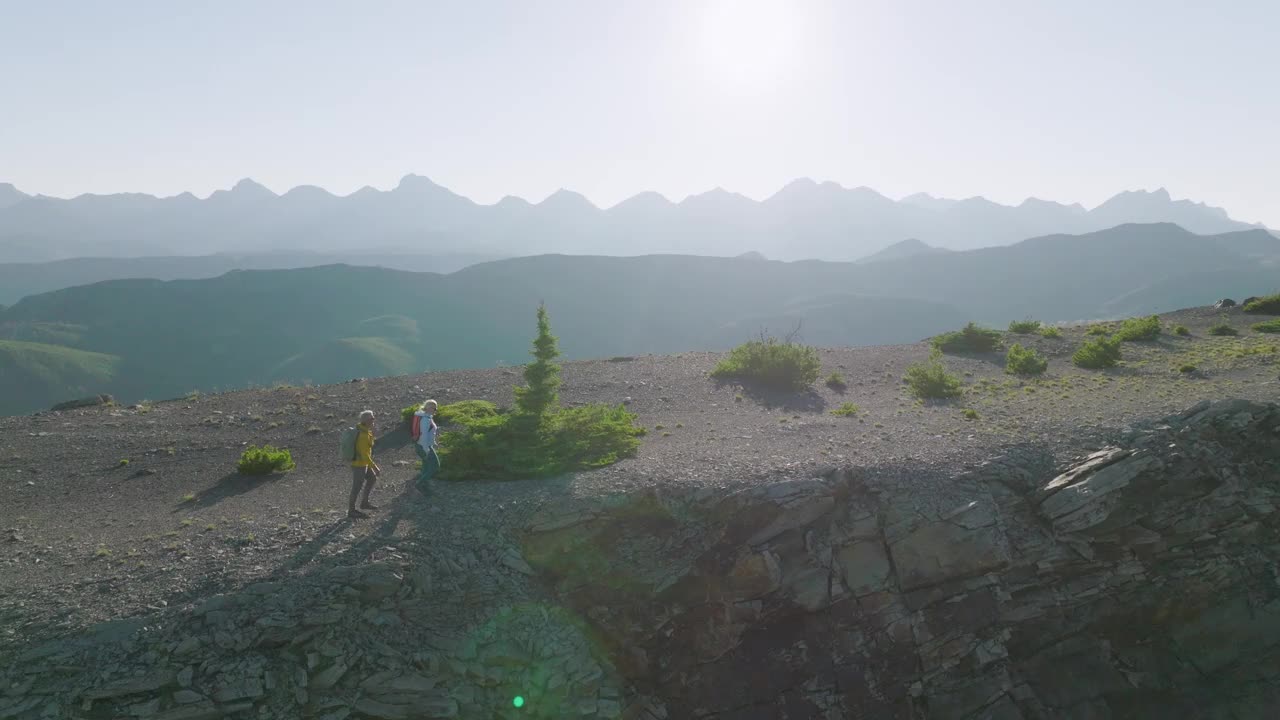 鸟瞰在山脊上徒步旅行的成熟夫妇视频素材