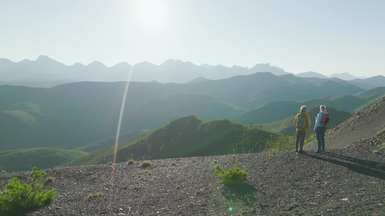 鸟瞰在山脊上徒步旅行的成熟夫妇视频素材