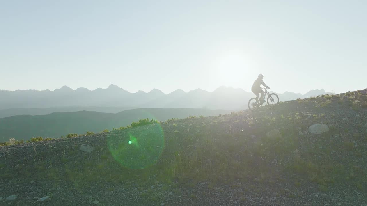 空中俯瞰骑山地自行车沿着高山山脊视频素材