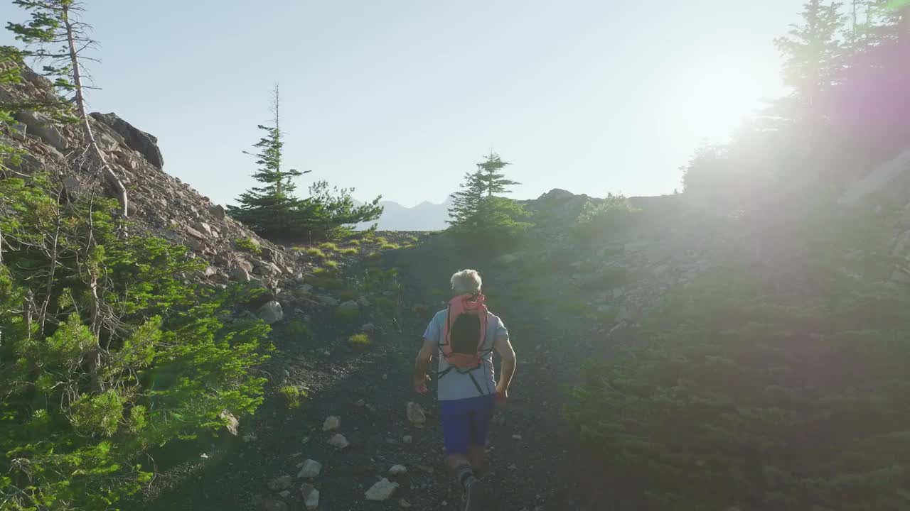 成熟的越野跑运动员沿着高山脊奔跑的鸟瞰图视频素材