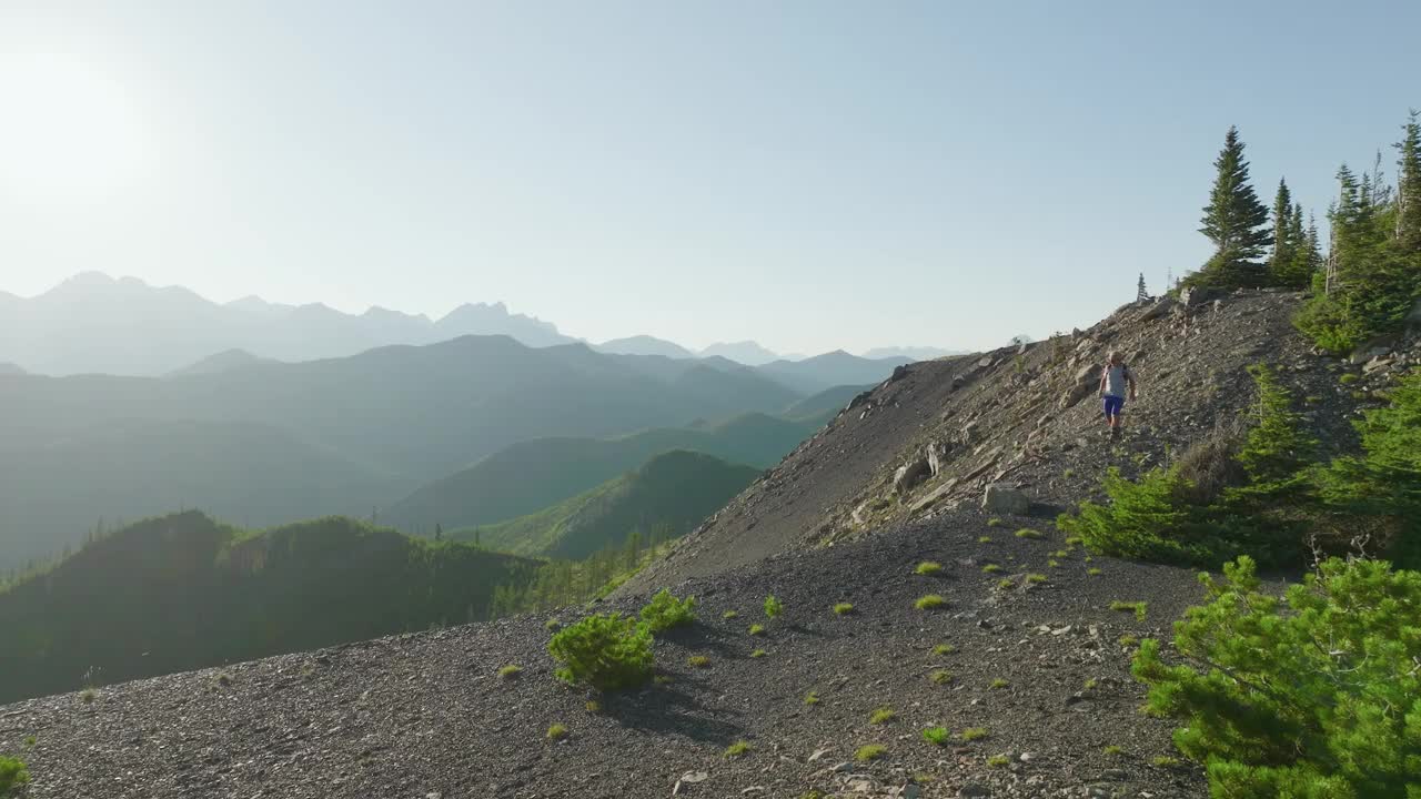 鸟瞰成熟的越野跑者沿着高山脊奔跑视频素材