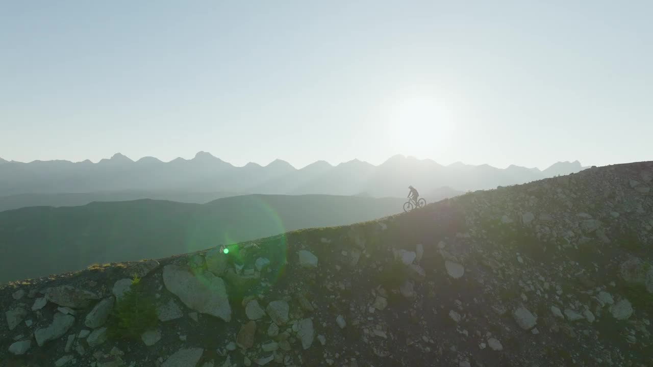 空中俯瞰骑山地自行车沿着高山山脊视频素材