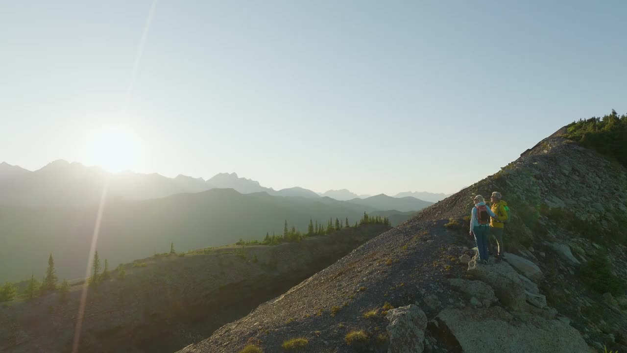 鸟瞰在山脊上徒步旅行的成熟夫妇视频素材