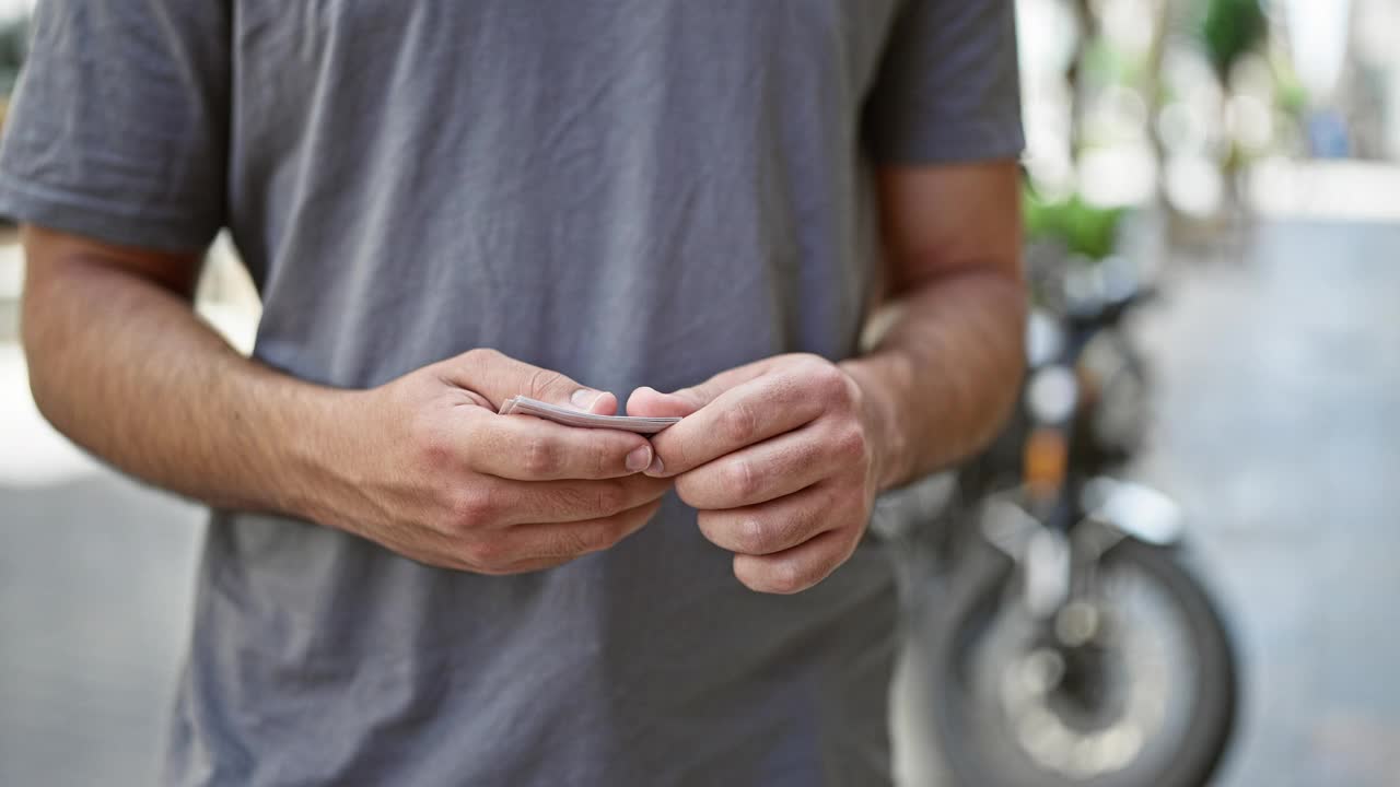 年轻的拉丁男子微笑着自信地在街上数钱视频素材