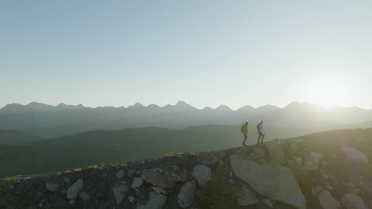 鸟瞰在山脊上徒步旅行的成熟夫妇视频素材