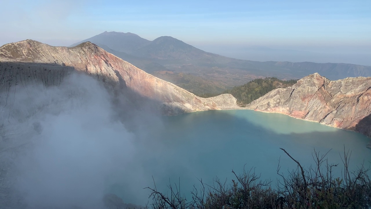 日出后，卡瓦伊真火山口火山的岩石悬崖与绿松石硫磺湖水。印尼东爪哇的旅游景点。自然景观背景。视频素材