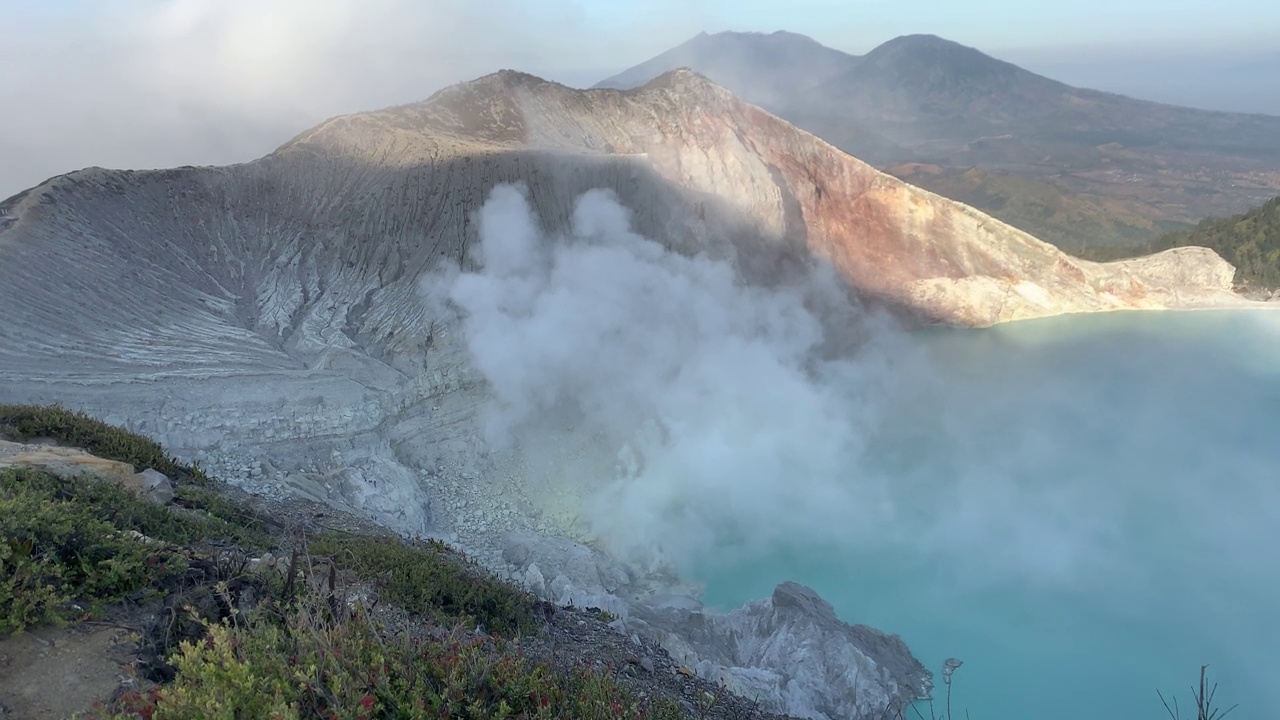 日出后，卡瓦伊真火山口火山的岩石悬崖与绿松石硫磺湖水。印尼东爪哇的旅游景点。自然景观背景。视频素材