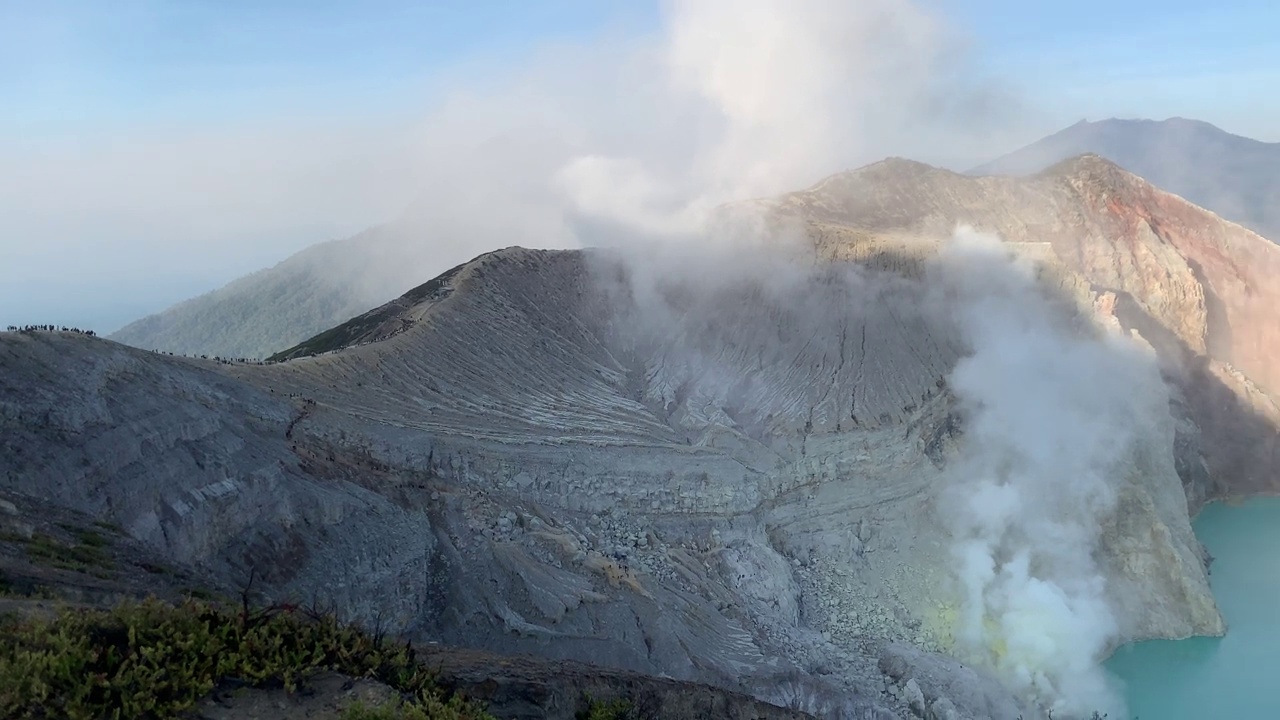 日出后，卡瓦伊真火山口火山的岩石悬崖与绿松石硫磺湖水。印尼东爪哇的旅游景点。自然景观背景。视频下载