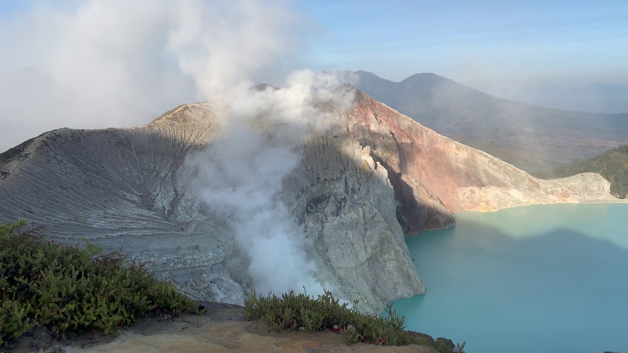 日出后，卡瓦伊真火山口火山的岩石悬崖与绿松石硫磺湖水。印尼东爪哇的旅游景点。自然景观背景。视频素材