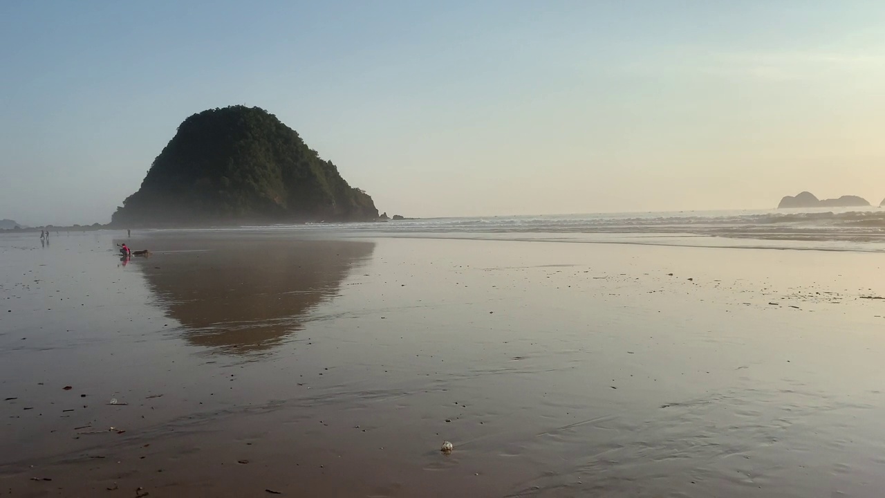 夕阳越过海浪冲刷沙滩。自然海景。印度尼西亚东爪哇岛班尤旺吉岛的红岛海滩。视频素材