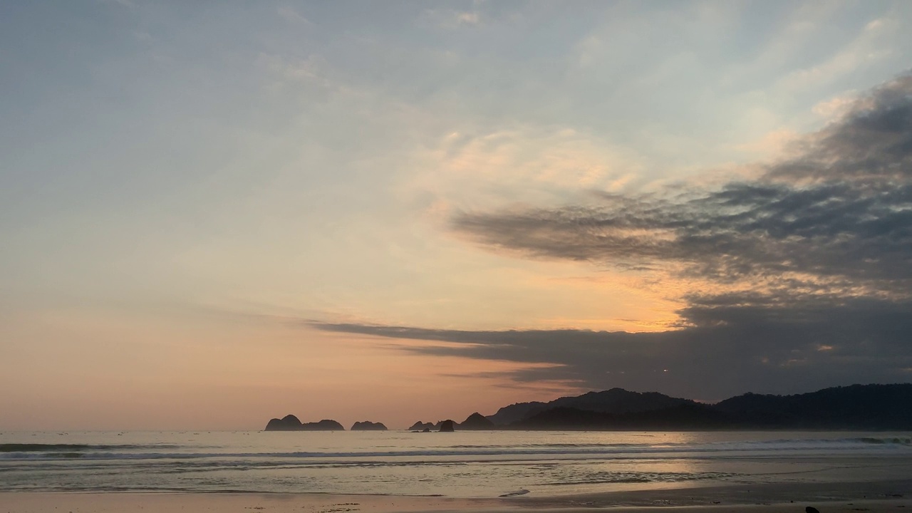 夕阳越过海浪冲刷沙滩。自然海景。印度尼西亚东爪哇岛班尤旺吉岛的红岛海滩。视频素材