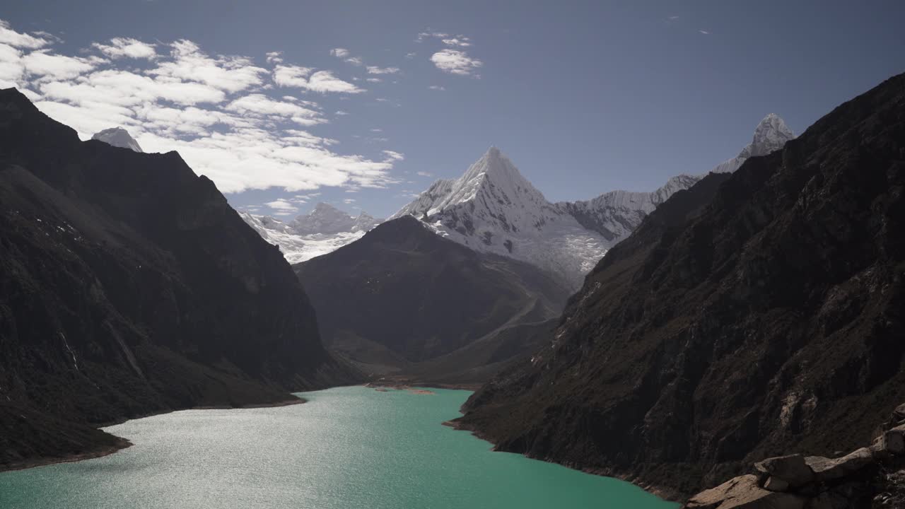 美丽的绿松石湖水在拉古纳帕隆泻湖在安第斯山脉的高山山脉在秘鲁华斯卡兰，雪山覆盖的山峰在一个明媚的阳光灿烂的一天。视频素材