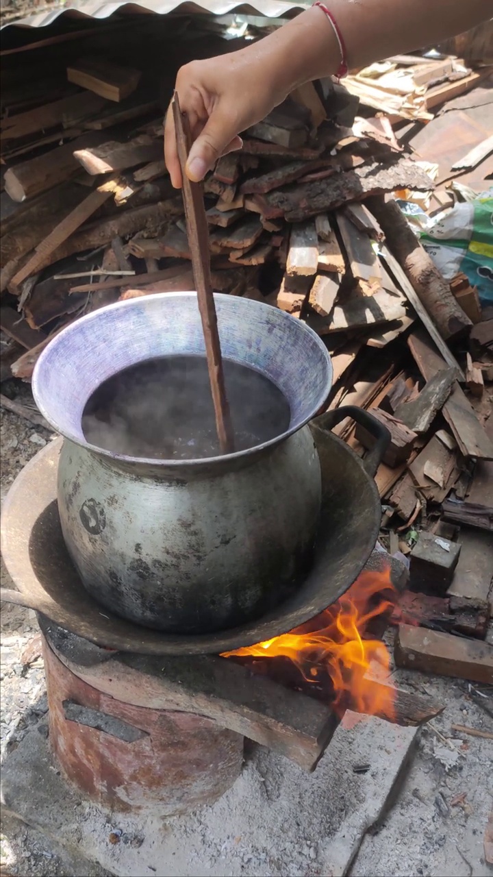 窑炉用黑炭烧制一锅染料溶液。视频素材