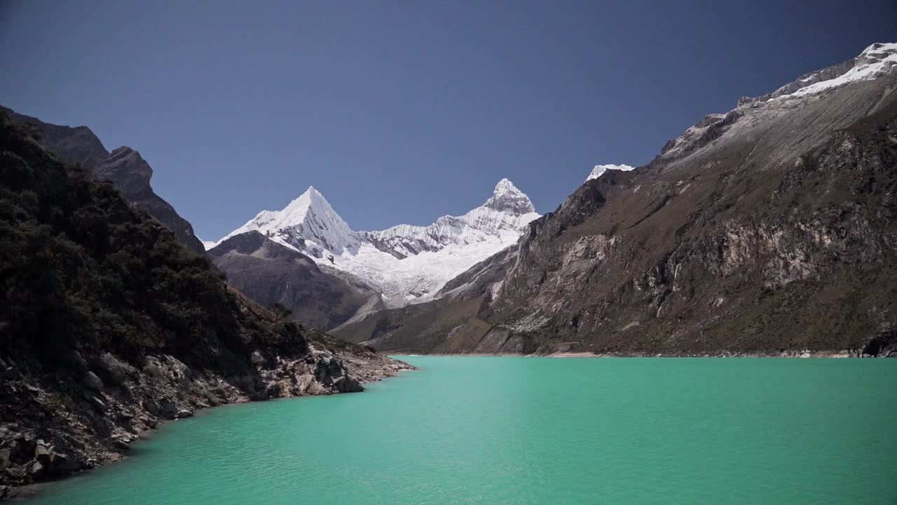 美丽的绿松石湖水在拉古纳帕隆泻湖在安第斯山脉的高山山脉在秘鲁华斯卡兰，雪山覆盖的山峰在一个明媚的阳光灿烂的一天。视频素材